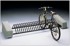 a bike is parked next to a bench made out of concrete blocks and steel bars