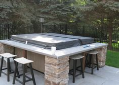 an outdoor hot tub surrounded by stools