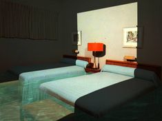 there are two beds in the room with blue sheets on them and one has a red lamp