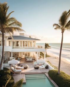 a large white house with palm trees and an ocean view