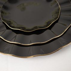 two black and gold plates sitting on top of each other