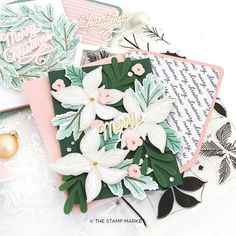 some cards with flowers on them sitting next to each other and one has a christmas ornament