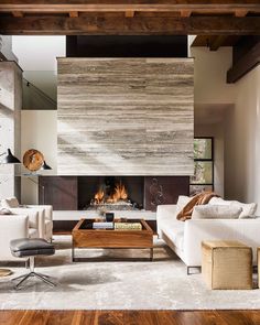 a living room with white couches and a fire place in the middle of it