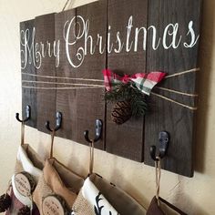 christmas stockings hanging on the wall with wooden signs and hooks attached to them that say merry christmas