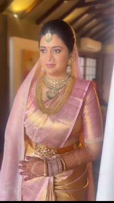 a woman in a pink and gold sari