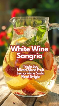 white wine sangria with mixed fruit and lemon - lime soda in a glass pitcher