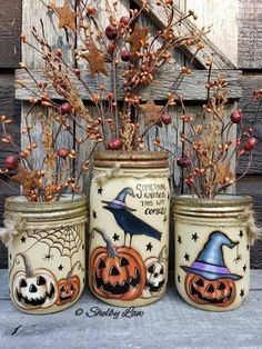 three decorated jars with pumpkins and witches on them