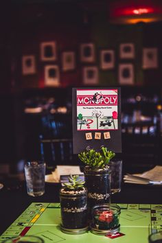 there is a sign on the table that says monopoly with succulents in it