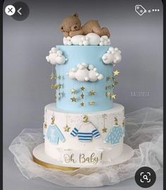 a blue and white baby shower cake with teddy bears on top