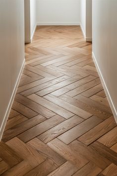 an empty hallway with wood flooring and white walls