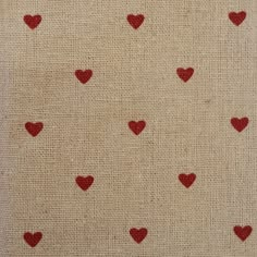 red hearts are arranged on the beige fabric