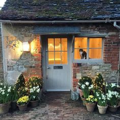 there is a dog that is standing in the window above the door to this house