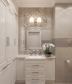 a bathroom with white cabinets and marble counter tops