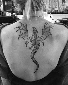 a woman with a dragon tattoo on her back