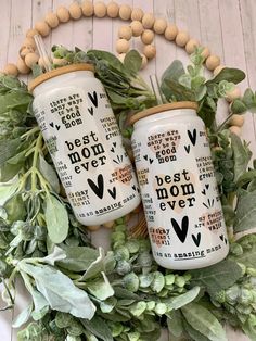 two personalized coffee mugs with the words best mom ever on them surrounded by greenery