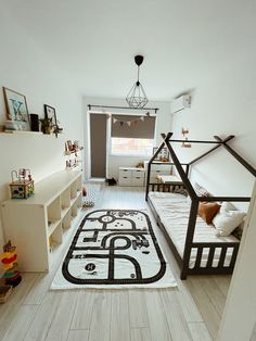 a bedroom with two beds and a rug on the floor in front of it,