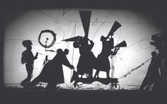 black and white silhouettes of people standing in front of a wall with musical instruments