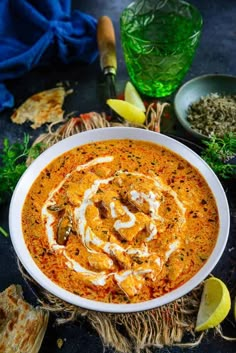 a white bowl filled with soup next to some bread