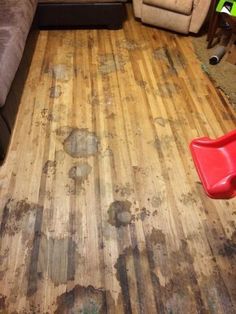 a living room with dirty wood floors and furniture