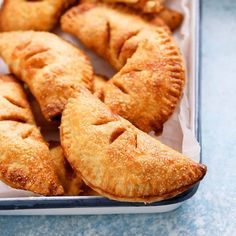 several pastries in a plastic container on a blue table top with one cut out