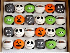 a box filled with lots of decorated cupcakes in the shape of pumpkins