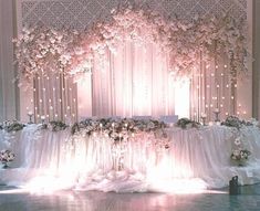 an image of a wedding stage setting with flowers and lights on the wall behind it