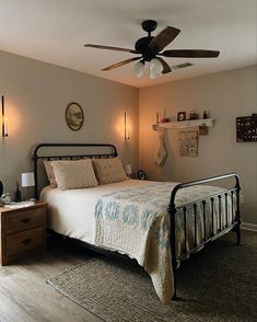 a bed room with a neatly made bed and a ceiling fan