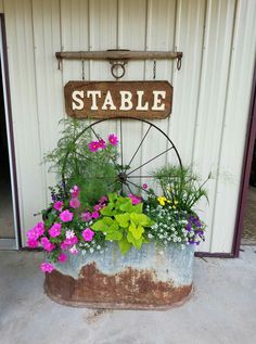 a potted planter filled with flowers next to a sign that says stable on it