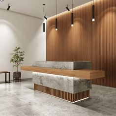 an empty lobby with wooden paneling and concrete counter top, along with two planters