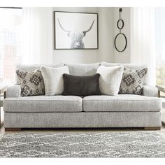 a living room scene with focus on the couch and pillows in front of the window