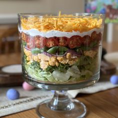 a layered salad in a glass dish on a table