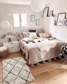 a bedroom with white walls, wooden floors and lots of pictures hanging on the wall