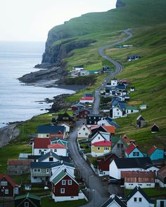 an aerial view of a small town by the ocean with many houses on it's sides