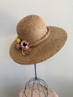 This is a vintage 1950's straw sun hat. The hat is intricately woven with a braided section across the brim. There is also pink tone faux floral details. By the faux flowers there are also plastic faux fruit adding a pop of color and texture. The hat is in excellent condition.Measurements:Circumference: 21" | Inside Depth: 5.5" | Brim Depth: 4" | Brim Circumference: 46"Unless otherwise stated all vintage items are used and may have minor to moderate wear or discoloration considering the age of t Bohemian Pink Sun Hat For Garden Party, Pink Bohemian Sun Hat For Garden Party, Summer Pink Straw Hat For Garden Party, Pink Summer Straw Hat For Garden Party, Vintage Straw Hat For Spring Wedding, Vintage Summer Wedding Boater Hat, Pink Straw Hat With Short Brim, Vintage Spring Wedding Straw Hat, Bohemian Straw Hat For Kentucky Derby Garden Party