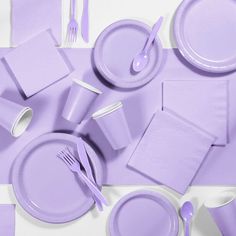 a purple table setting with napkins, plates and utensils on the table