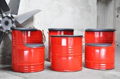 three red barrels sitting next to each other with a propeller in the middle and one on top