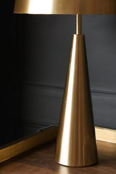 a gold lamp sitting on top of a wooden floor