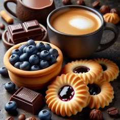 blueberries, cookies, and coffee are on the table next to some chocolates