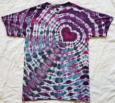 a t - shirt with a spiral design on the front and purple, blue, and green colors