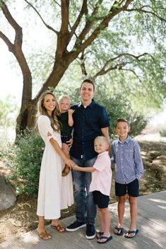 a family posing for a photo in front of a tree