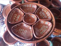 many brown bowls are stacked on top of each other in the shape of a flower