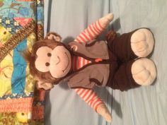 a monkey stuffed animal sitting on top of a bed