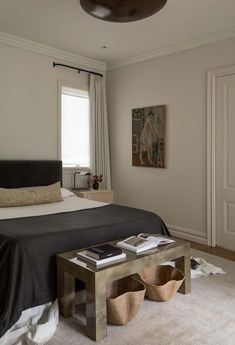 a bedroom with white walls and carpeted flooring, along with a bed covered in black sheets