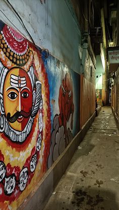 an alleyway with graffiti on the walls and below it is a painting of a man's face