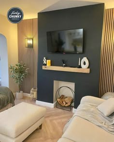 a living room filled with furniture and a flat screen tv mounted on the wall above a fireplace