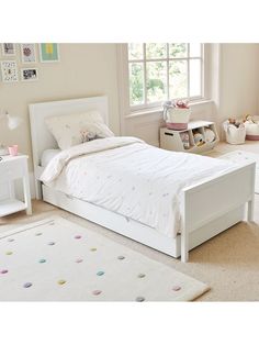 a child's bedroom with white furniture and decor