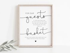 a white framed sign with the words for our guests to basket on it next to a plant