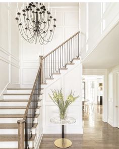 an elegant foyer with white walls and wood floors