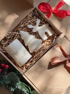 three candles in a gift box with red ribbon