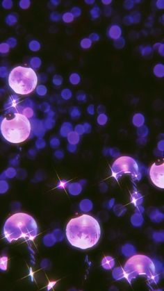 purple bubbles floating in the air with sparkles on it's sides and dark background